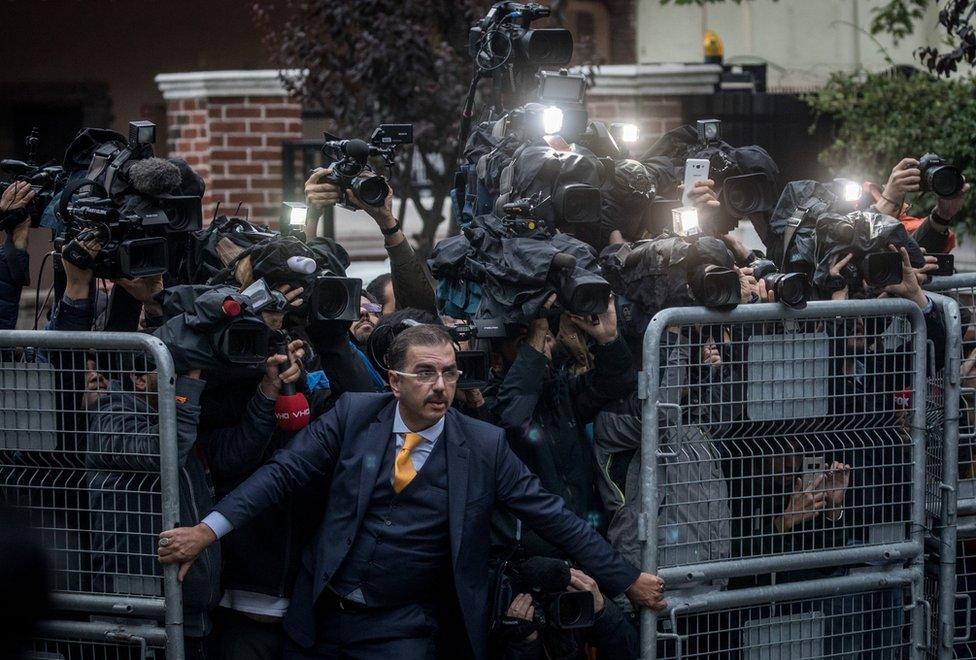 A man attempts to hold back press at the Saudi Arabian consulate in Istanbul, Turkey