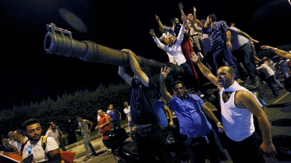 People stand on a tank during a failed coup attempt in Turkey