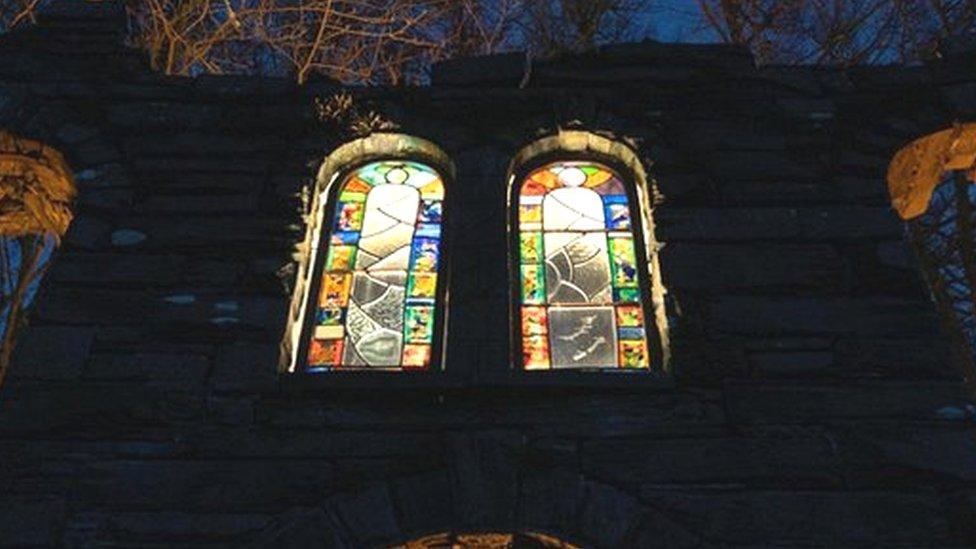 The chapel lit up at night, with Christina's stained glass windows