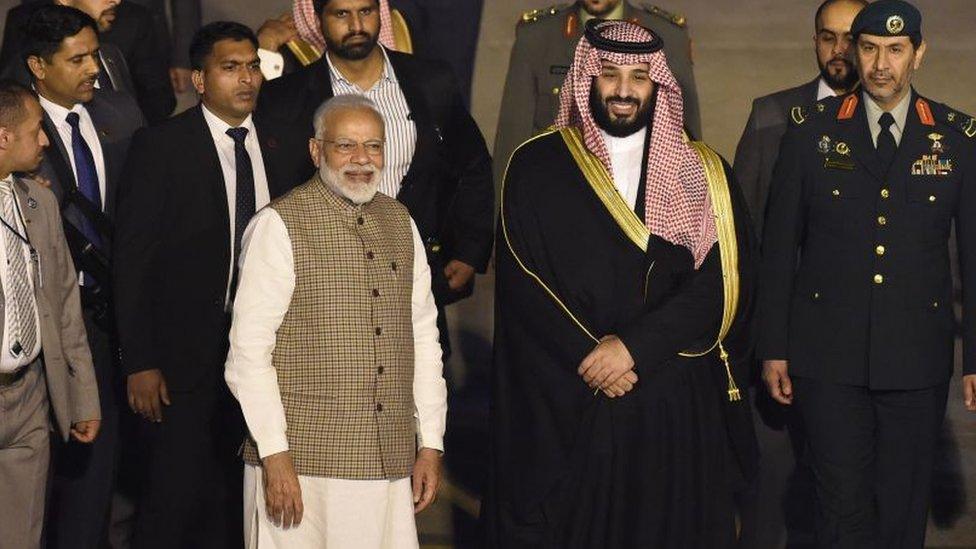 Saudi Crown Prince Mohammed Bin Salman stands next to Indian Prime Minister Narendra Modi (L) upon arriving at the airport in New Delhi on February 19, 2019.