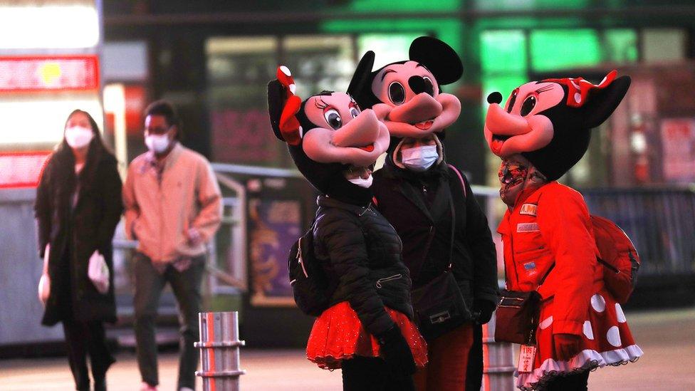 people wearing Minnie Mouse and Mickey Mouse costumes engage in conversation in Times Square on March 15, 2021 in New York City. After undergoing various shutdown orders for the past 12 months the city is currently in phase 4 of it's reopening plan, allowing for the reopening of low-risk outdoor activities, movie and television productions, indoor dining as well as the opening of movie theaters, all with capacity restrictions. (