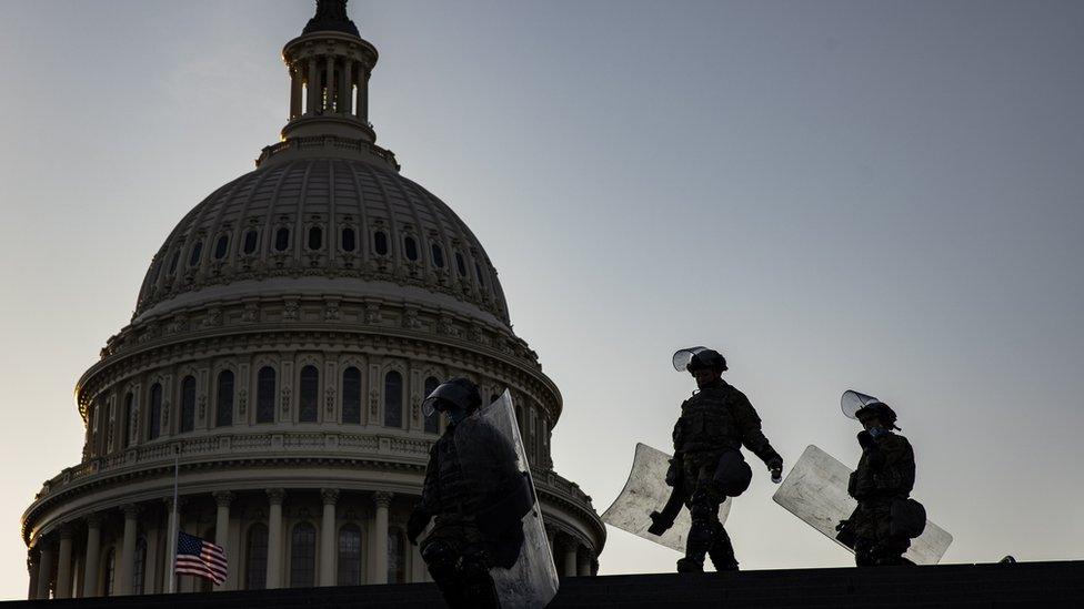 National Guard soldiers with riot shields head to the Capitol Visitors Center after being deployed to secure the grounds around the US Capitol building in Washington, DC, USA