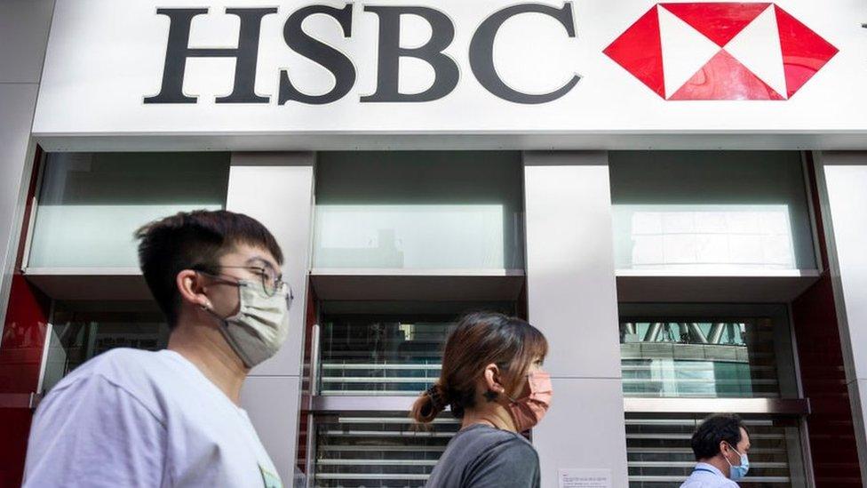 Pedestrians walk past the British multinational banking and financial services holding company, HSBC in Hong Kong.