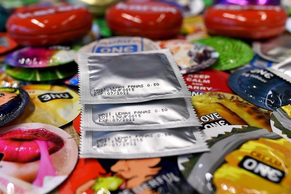 In this picture taken 20 September 2017, packs of 'nasi lemak' flavoured condoms are seen amidst others at the Malaysian condom-maker Karex Industries headquarters in Port Klang.