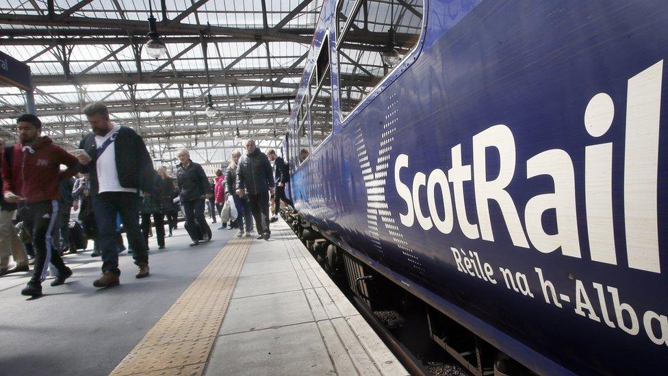 A Scotrail train at a station with people disembarking