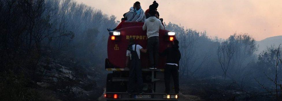 Firefighters and local people try to extinguish a forest fire in the Lustica Peninsula near Tivat, Montenegro, 17 July 2017