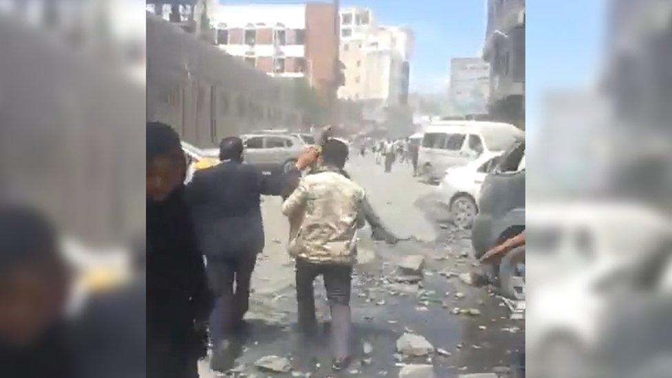 A man carrying an injured person who has been dug out of the rubble following an airstrike in Sana'a, Yemen