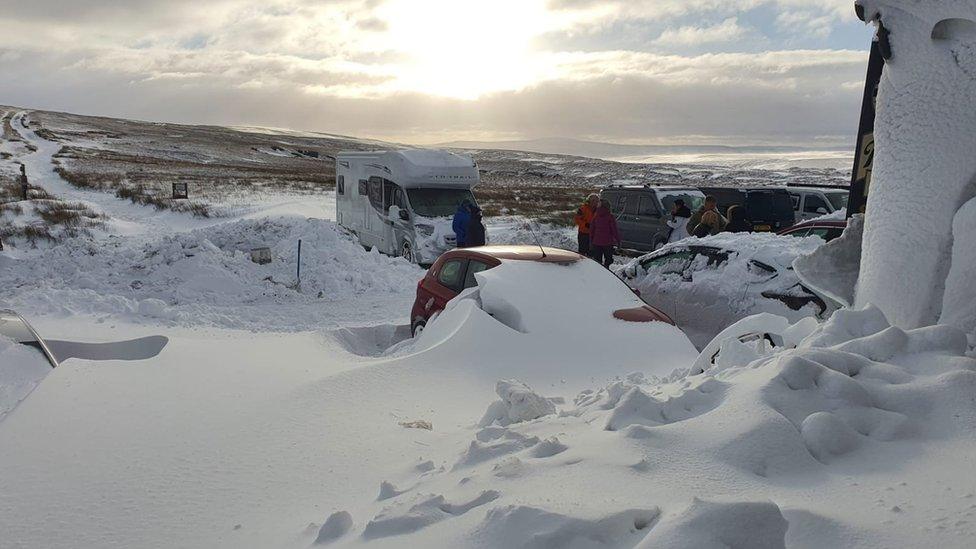 Snow covers cars at the Tan Hill