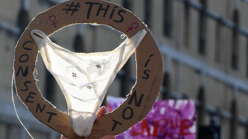 A woman holds up a G-string during a march on the eve of the International Day for the Elimination of Violence against Women on November 24, 2018 in Marseille, southern France