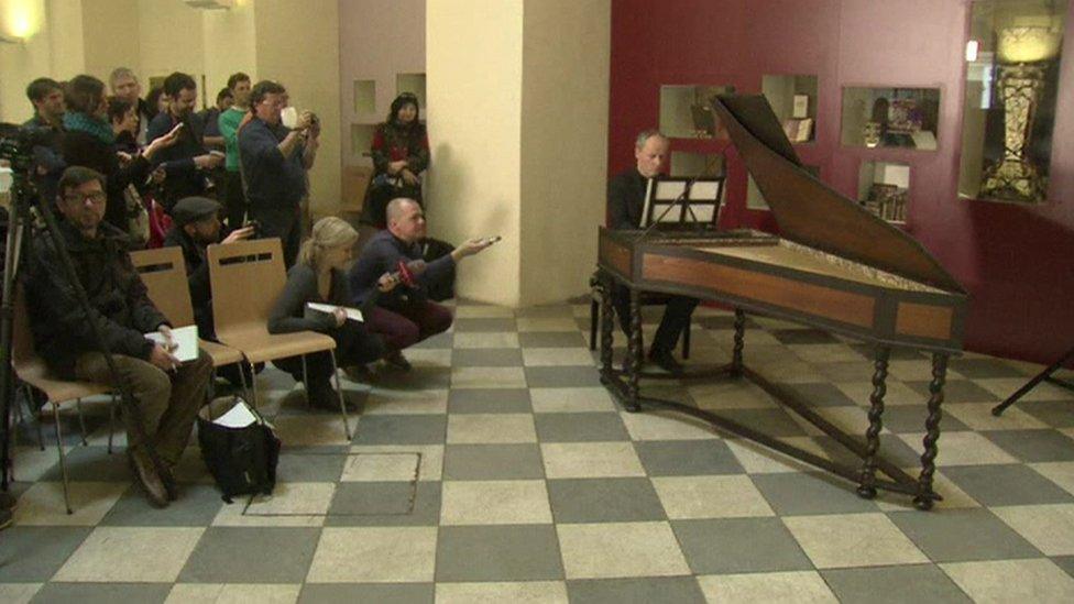 harpsichordist at instrument with sheet music