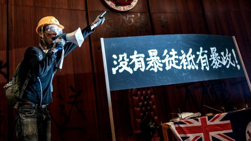 A protester talks into a megaphone after they broke into the parliament chamber of the government headquarters