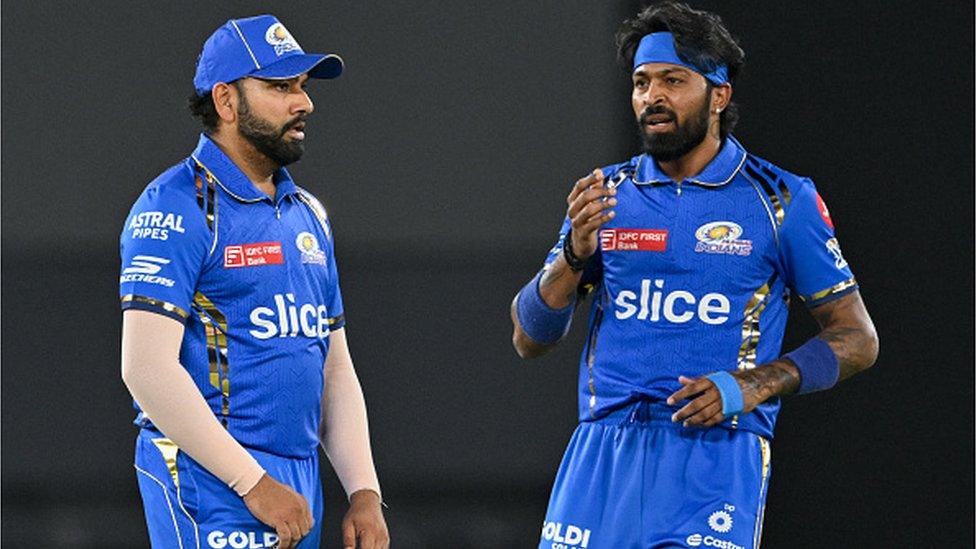 Mumbai Indians' captain Hardik Pandya and his teammate Rohit Sharma (L) gesture during the Indian Premier League (IPL) Twenty20 cricket match between Gujarat Titans and Mumbai Indians at the Narendra Modi Stadium in Ahmedabad on March 24, 2024. (