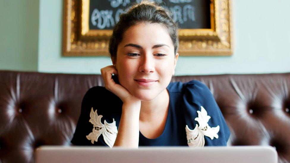 Woman on laptop in cafe