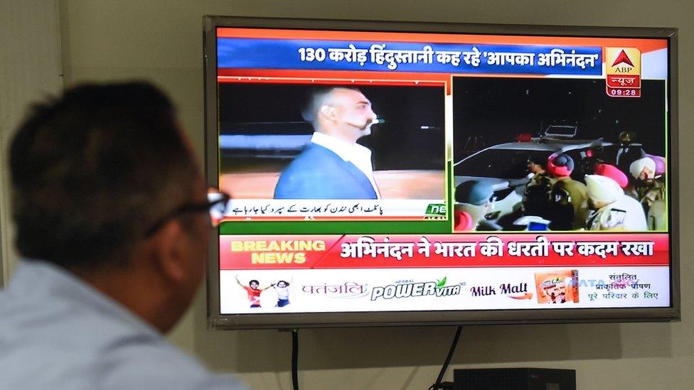 An Indian man watches live news channels broadcasting images of Indian Air Force (IAF) Wing Commander pilot Abhinandan Varthaman returning to India from the India-Pakistan Wagah border in New Delhi on March 1, 2019.