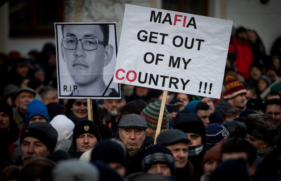 People hold placards during a silent protest march in Bratislava