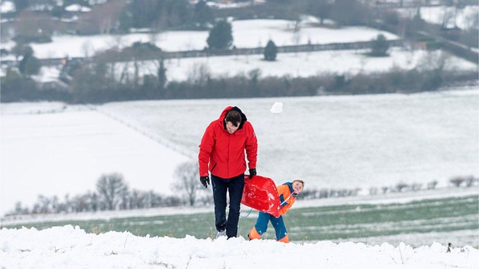 A snowball in mid-flight as people go sledging near Brighton.