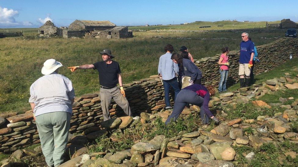 Volunteers work on stone dyke