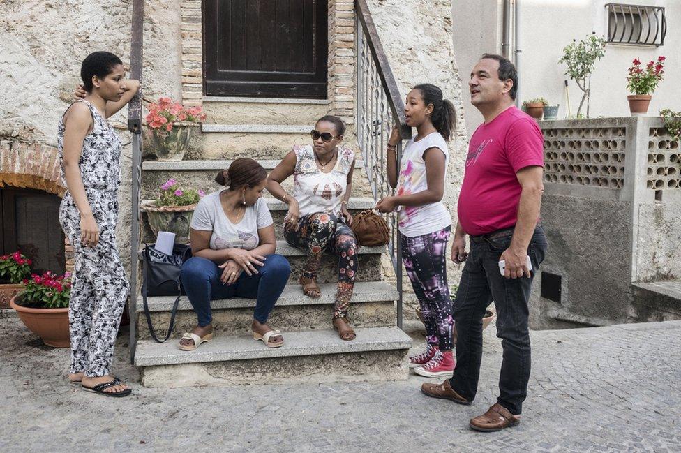 Riace's three-term mayor, Domenico Lucano chatting with a group of women from Horn of Africa