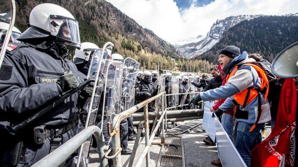 Riot police face protesters during a rally against the Austrian government's planned re-introduction of border controls at the Brenner Pass