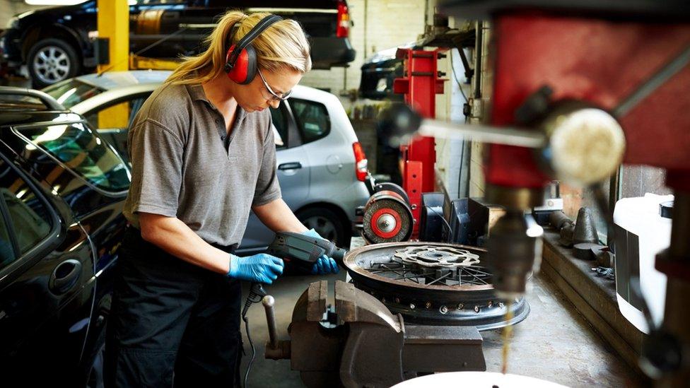 Woman working in car production plant