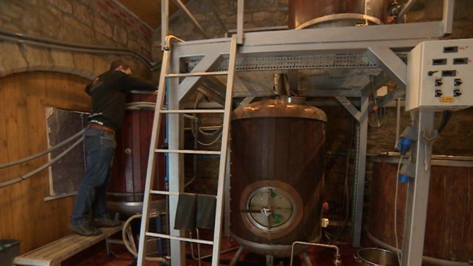 A staff member at work in the brewery