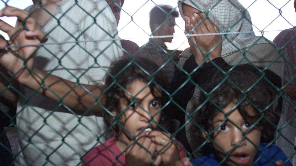 Asylum seekers arrive at Nauru off the Australian Navy troop carrier HMAS Manoora, 19 September 2001