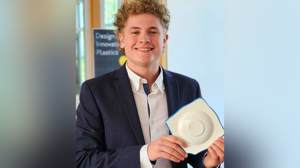 Harry Wragg looking at the camera smiling and holding his CPR prototype