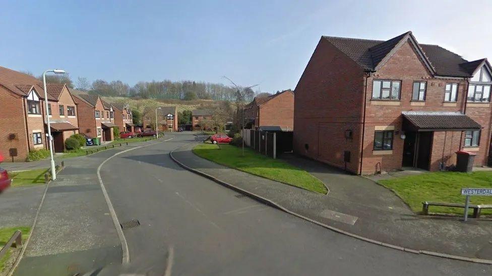 A view of Westerdale Close, a road with red-brick houses either side and a lamppost on one side