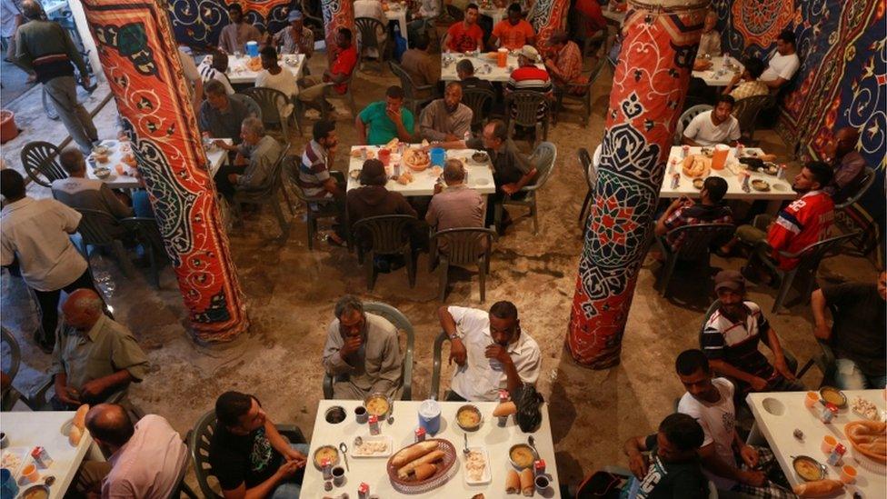 People eat their Iftar (breaking of fast) meal at tables offering free food, set up by a charity, during the holy fasting month of Ramadan in Benghazi, Libya, June 29, 2016.