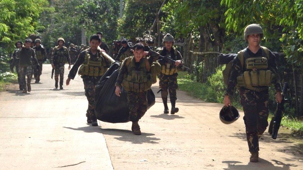 Troops carry bodies after a military operation against the Islamist militant group Abu Sayyaf in Sulu province, southern Philippines