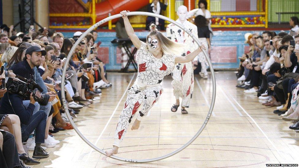 An acrobat in a hoop on the catwalk