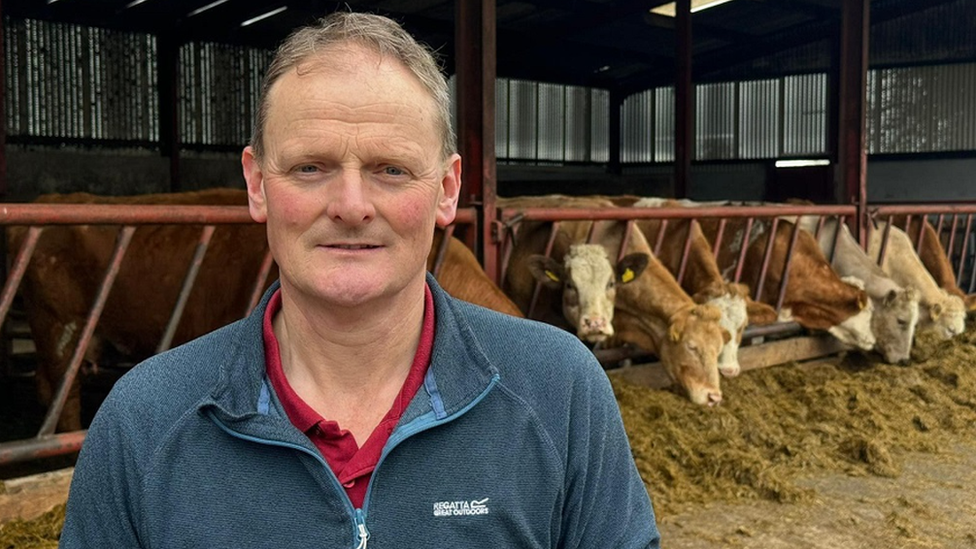 David Brown stands in front of his cows