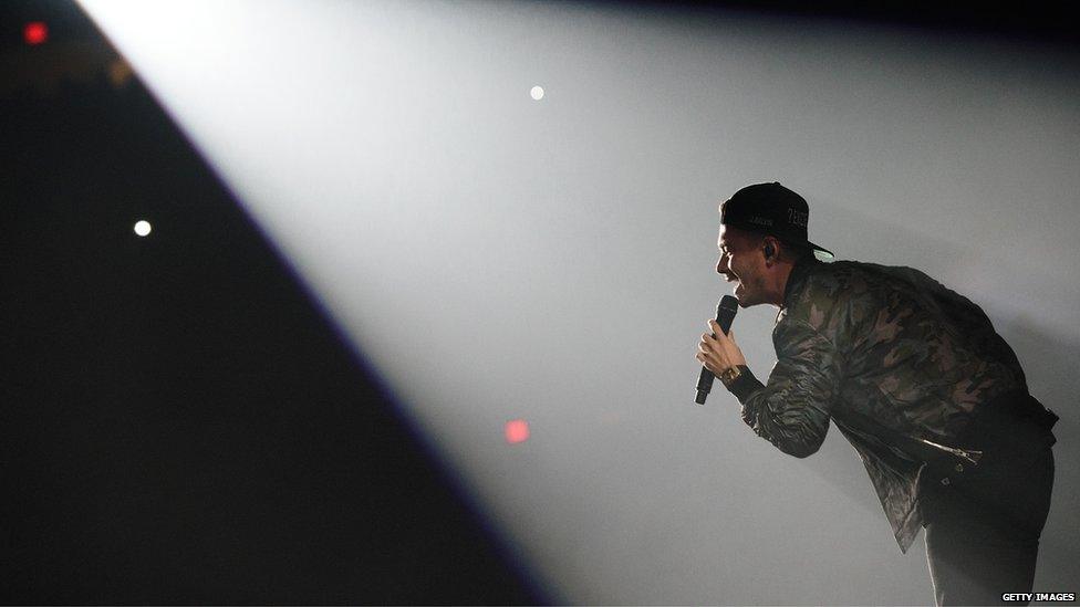 J Balvin performing under a spotlight