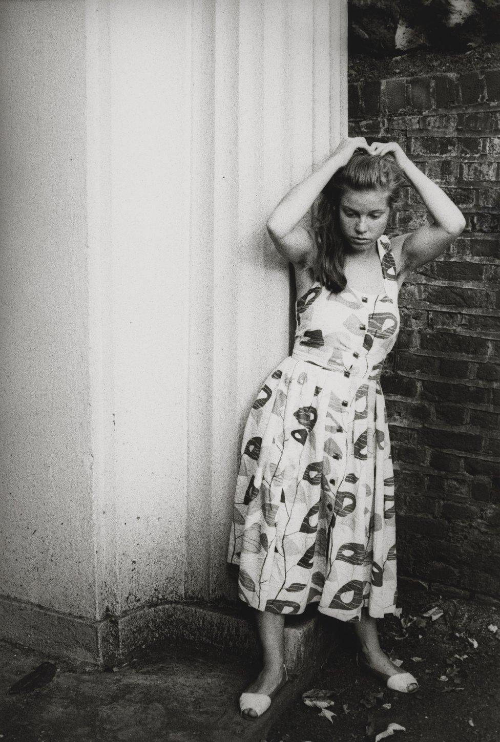 Alison Owen fixes her hair in a doorway, circa 1984