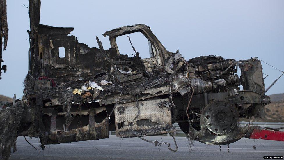 A truck damaged in a fire in southern California is towed away