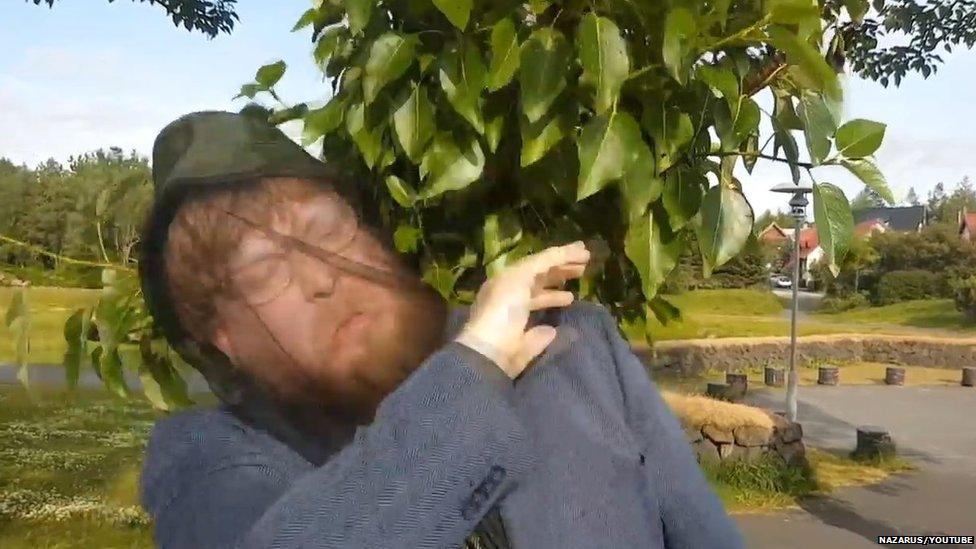 Man waving midges away in music video