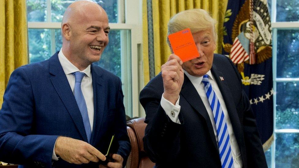 Trump jokingly shows a red card to the media during a meeting with the president of Fifa, Gianni Infantino