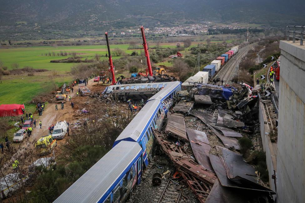 Police and emergency crews search the debris of a crushed wagon after the train accident.