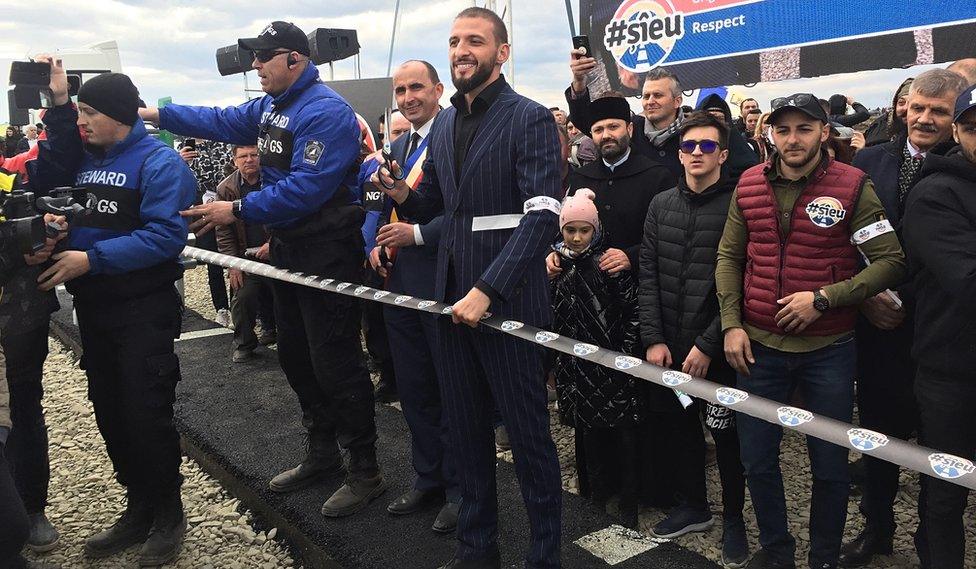 Stefan Mandachi cuts the ribbon across his motorway