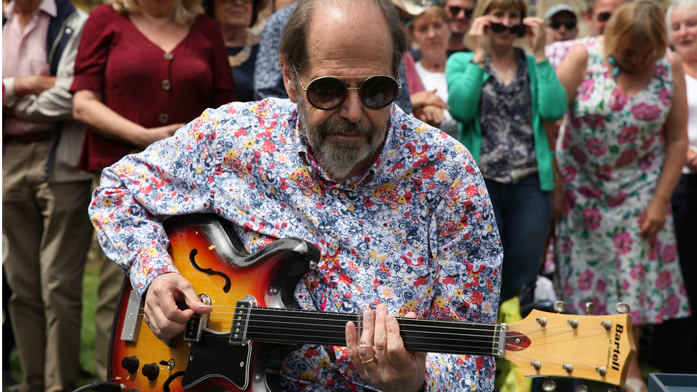 Musician Ray plays the guitar