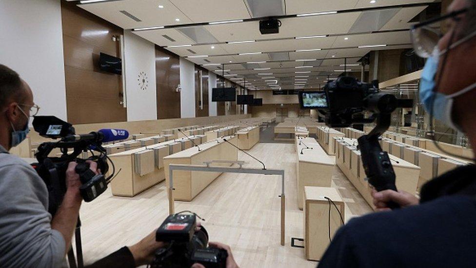 Photographers take pictures of the courtroom