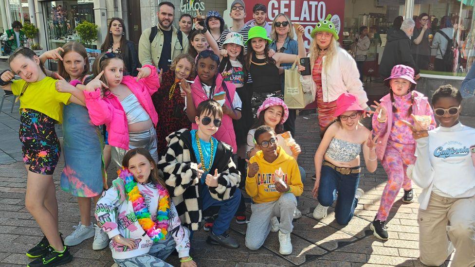 The young performers posing together on a street