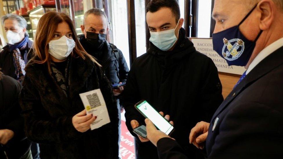 Customers have their green pass checked as they arrive at a bar