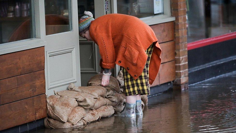 Woman stacking sandbags in Northwich