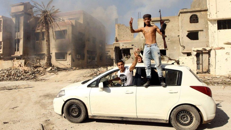 Libyan fighters celebrate on roof of a car