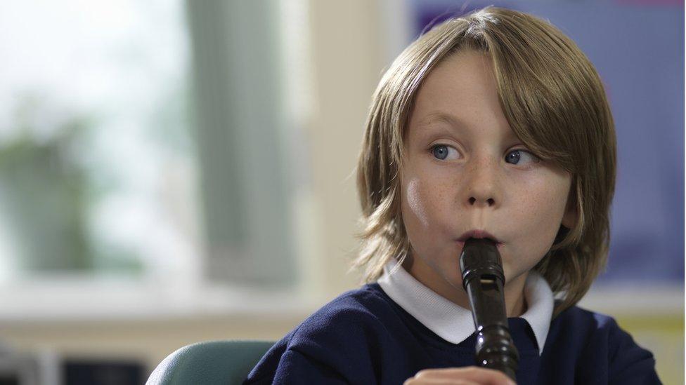 Young boy playing the recorder