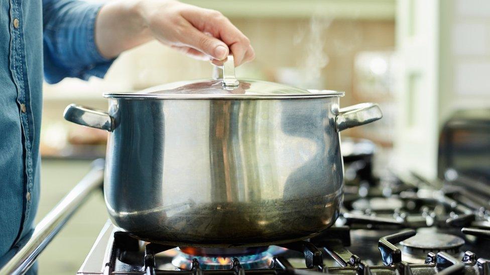 Person cooking on a gas hob