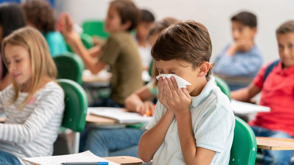 Boy sneezing in class