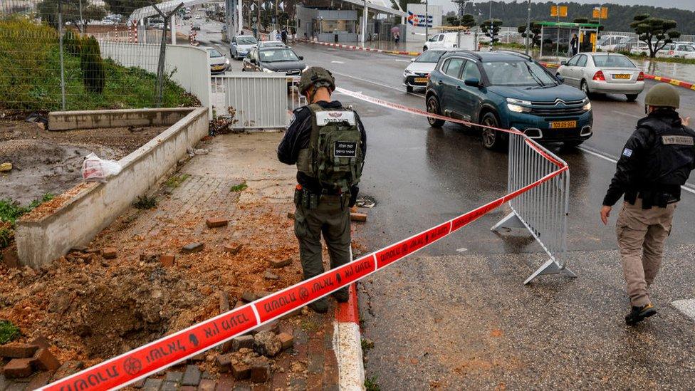 An Israeli policeman inspects the impact crater left by a rocket fired from southern Lebanon