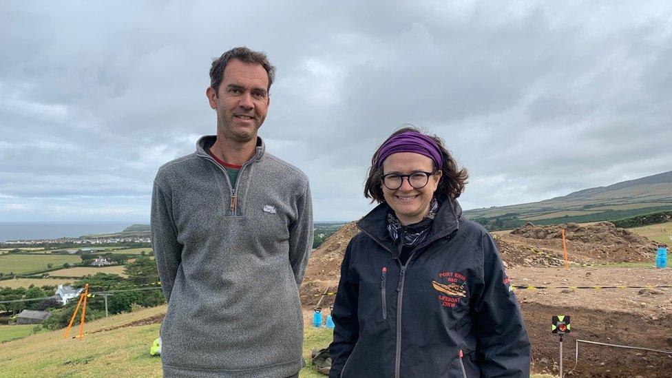 Chris Fowler and Rachel Crellin standing in front of the site of the dig